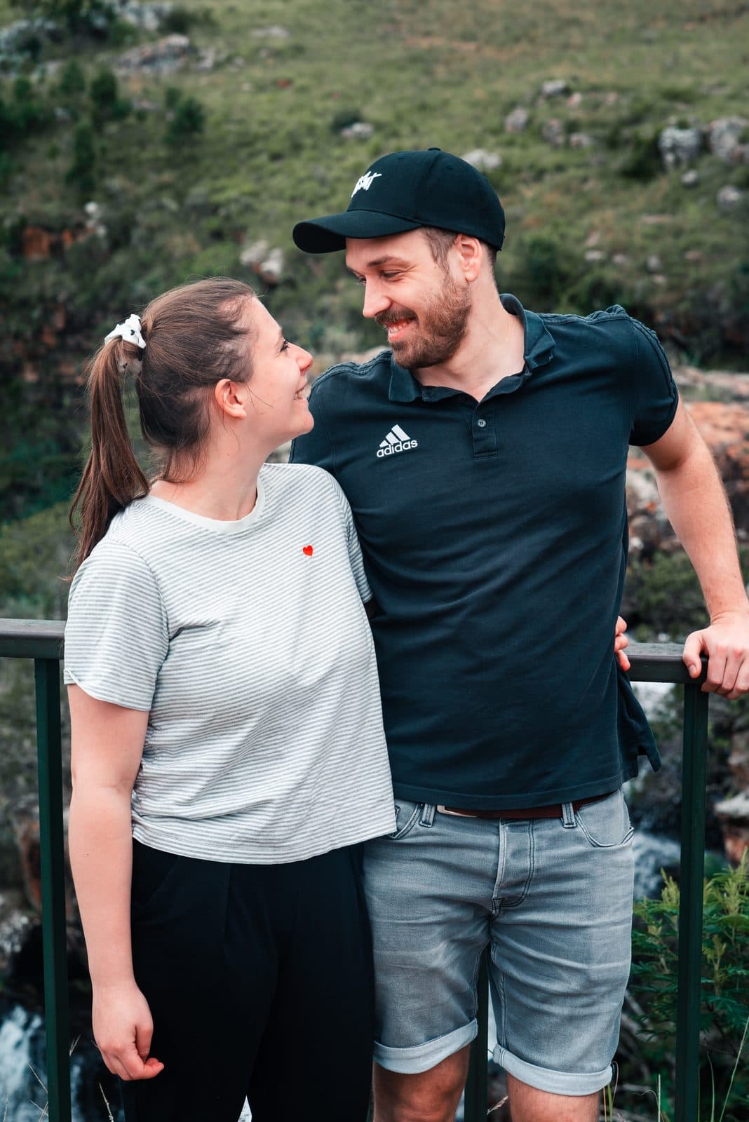 Lena und Jonas lachen sich am Geländer eines Aussichtspunkts an